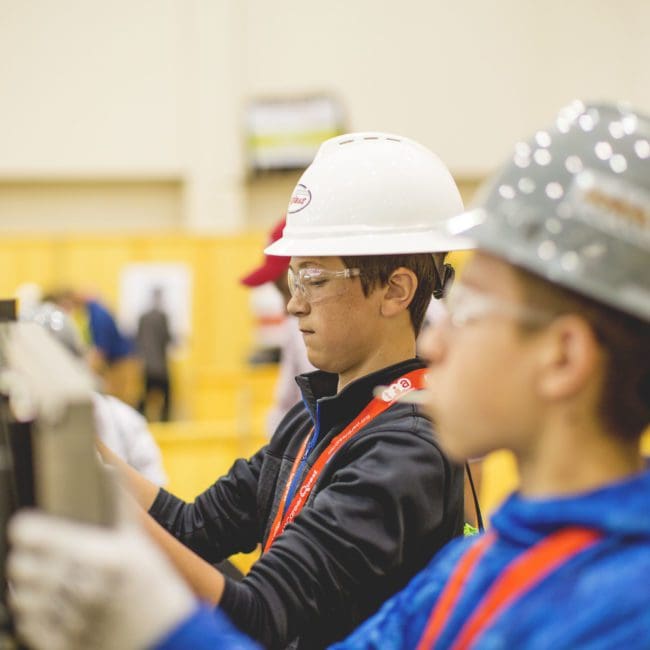 Male middle schoolers assemble woodwork