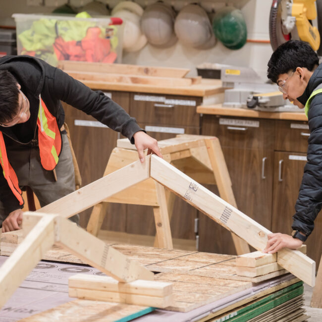 Two WMCI students in the Carpentry 1 and CORE course learn how to become carpenters by framing the exterior of a shed structure.