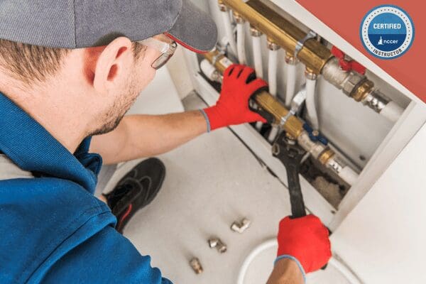 A student in plumbing 1 course connects a piping system