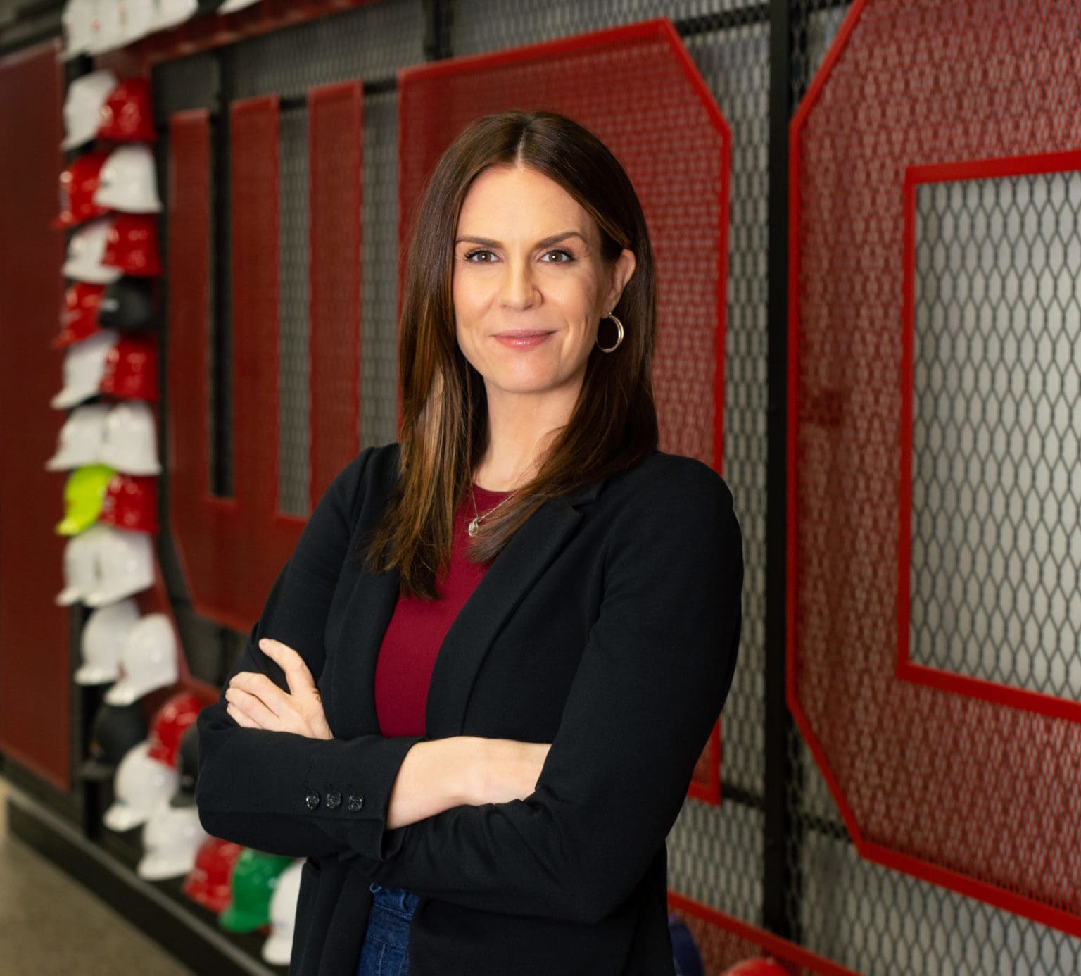 West Michigan Construction Institute Jen Schottke poses for a photo in front of the WMCI hard hat wall