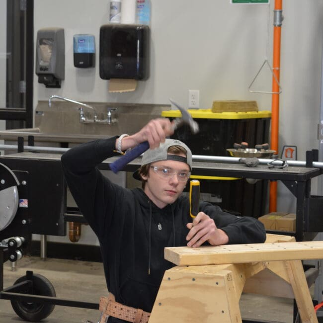 WMCI student using a hammer