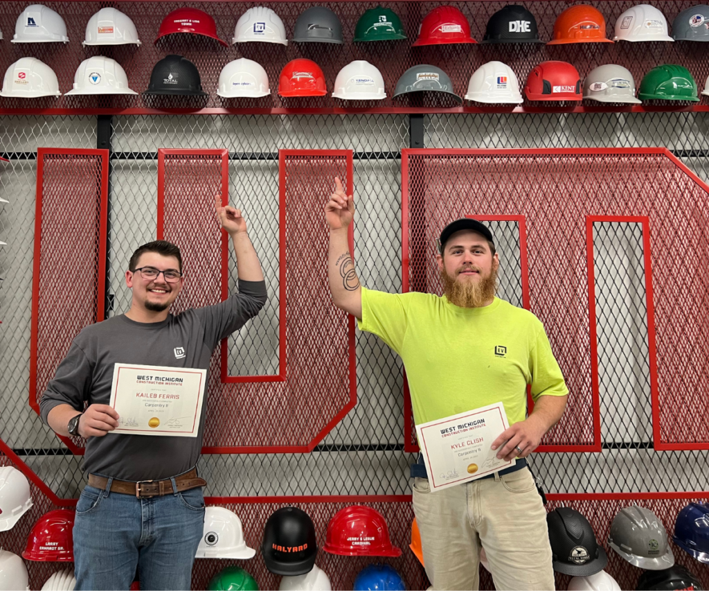 Two Carpentry students celebrate after graduating.