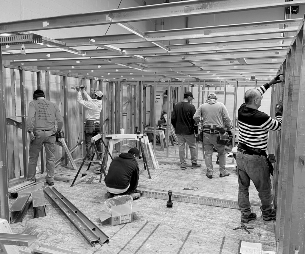 A group of carpentry students work to build a structure in the WMCI lab.